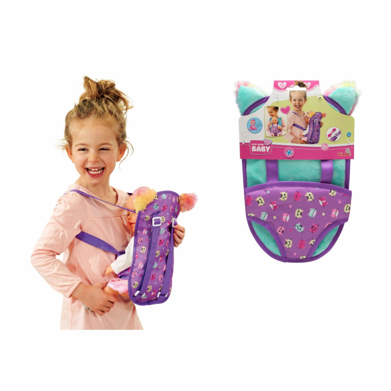 Lächelndes Mädchen mit Spielzeug-Babytrage rechts ist die Produktverpackung zu sehen. Lächelndes Mädchen mit Spielzeug-Babytrage rechts ist die Produktverpackung zu sehen.