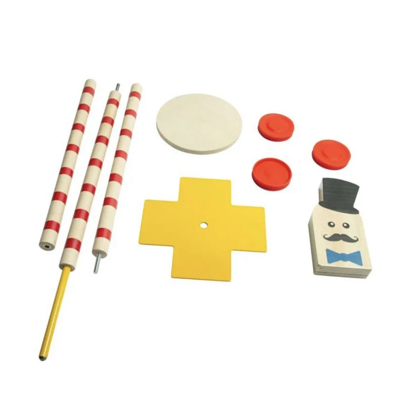 Spielzeuge: gestreifte Stäbe, gelbes Kreuz, rote Scheiben, weißer Kreis und ein Block mit Gesicht und Zylinder.