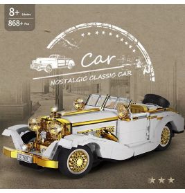 Spielzeugmodell eines weißen und goldenen Oldtimers mit detaillierten Scheinwerfern, Rädern und Ersatzreifen.