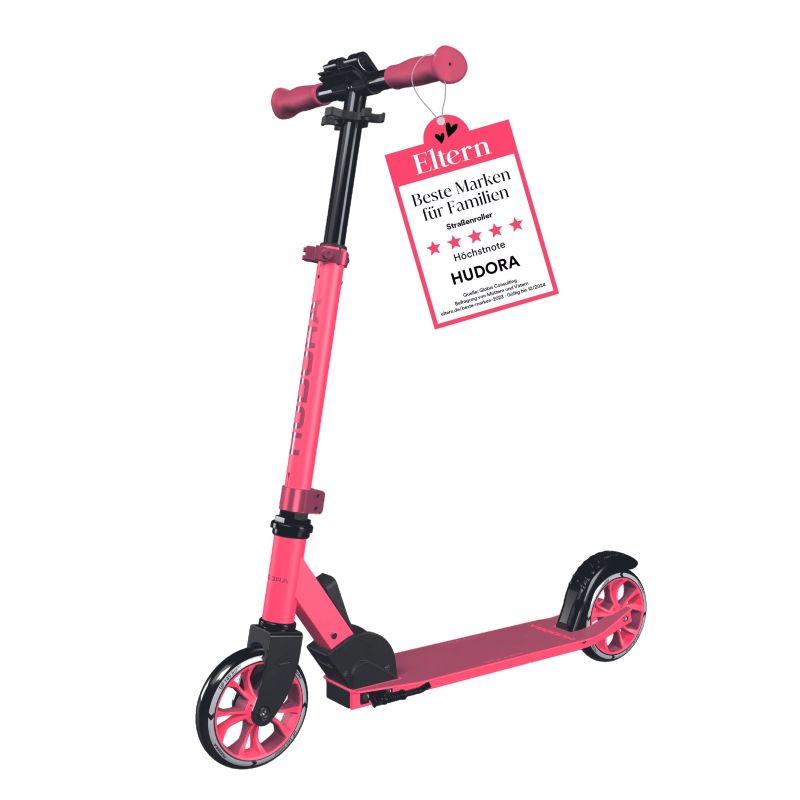 Pinkfarbener Tretroller mit schwarzen Details und rotem Anhänger am Lenker mit deutscher Aufschrift. Pinkfarbener Tretroller mit schwarzen Details und rotem Anhänger am Lenker mit deutscher Aufschrift.