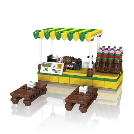 Im Lego-Stil gestalteter Imbissstand mit grün-gelbem Dach, Spießen und zwei braunen Tischen mit Tellern.