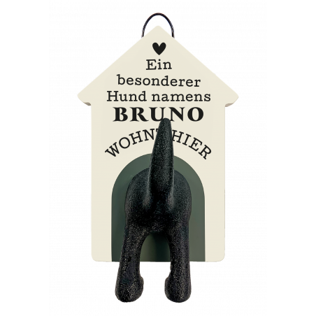 Aus einem Hundehäuschen-Schild mit der Aufschrift Ein besonderer Hund namens Bruno wohnt hier ragen Hundebeine.