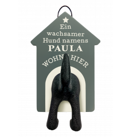 Hundeschwanz und Hinterbeine als Haken an einem Schild: Ein wachsamer Hund namens Paula wohnt hier.