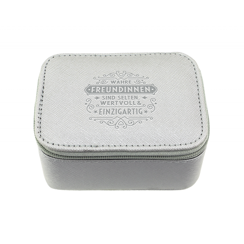 Kleine graue Box mit Reißverschluss, auf deren Deckel ein deutscher Schriftzug in Zierschrift steht. Kleine graue Box mit Reißverschluss, auf deren Deckel ein deutscher Schriftzug in Zierschrift steht.