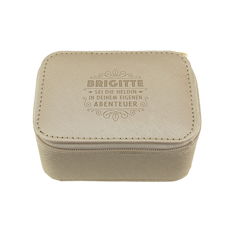 Beige Etui mit Reißverschluss und geprägtem Text: BRIGITTE SEI DIE HELDIN IN DEINEM EIGENEN ABENTEUER. Beige Etui mit Reißverschluss und geprägtem Text: BRIGITTE SEI DIE HELDIN IN DEINEM EIGENEN ABENTEUER.