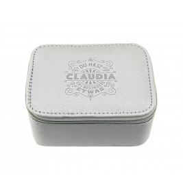 Hellgraue, rechteckige Box mit Reißverschluss auf dem Deckel sind Claudia und deutscher Text geprägt.