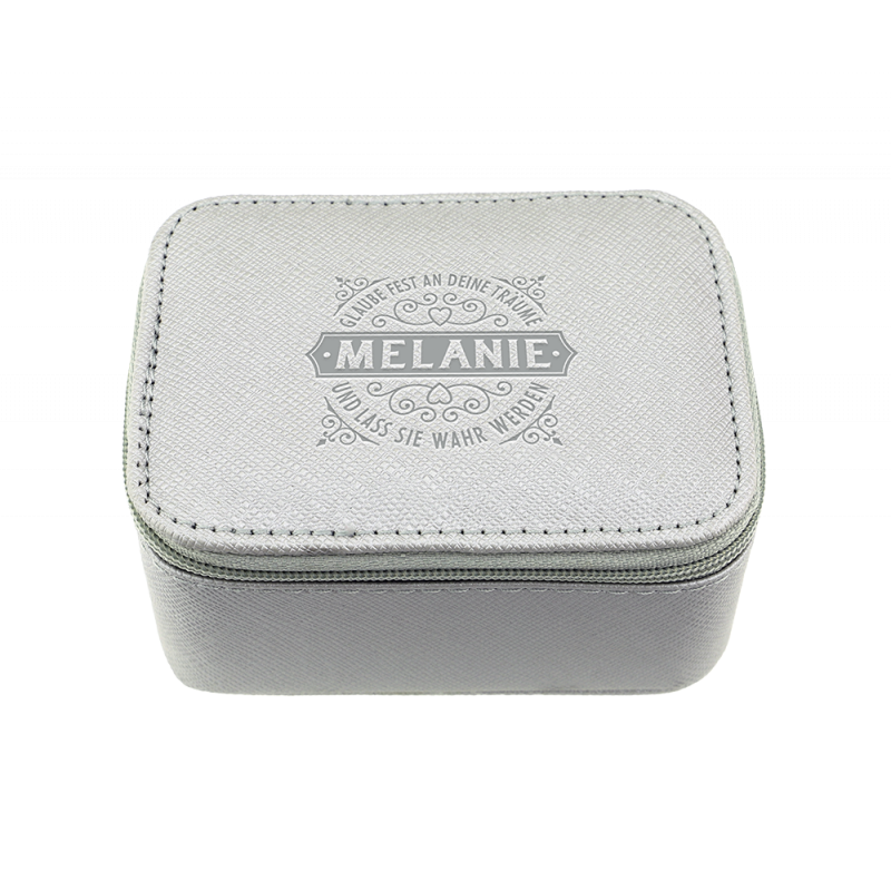 Kleine graue Box mit Reißverschluss, auf deren Deckel Melanie und dekorative Schriftzüge gedruckt sind.