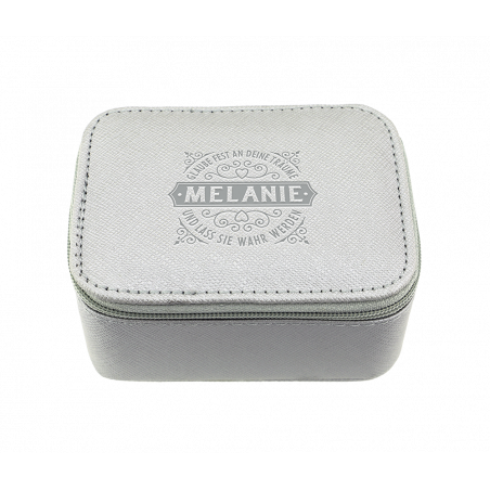 Kleine graue Box mit Reißverschluss, auf deren Deckel Melanie und dekorative Schriftzüge gedruckt sind.