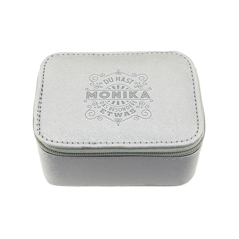 Kleine, hellgraue Box mit Reißverschluss, Monika und Ziertext sind auf dem Deckel geprägt. Kleine, hellgraue Box mit Reißverschluss, Monika und Ziertext sind auf dem Deckel geprägt.