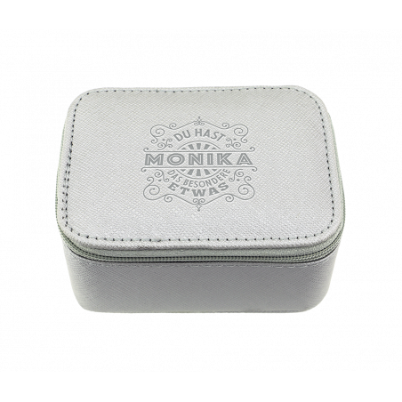 Kleine, hellgraue Box mit Reißverschluss, Monika und Ziertext sind auf dem Deckel geprägt.