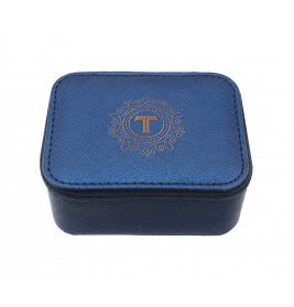 Kleine blaue Strukturbox mit goldenem verziertem T-Logo auf dem Deckel, vor weißem Hintergrund fotografiert.