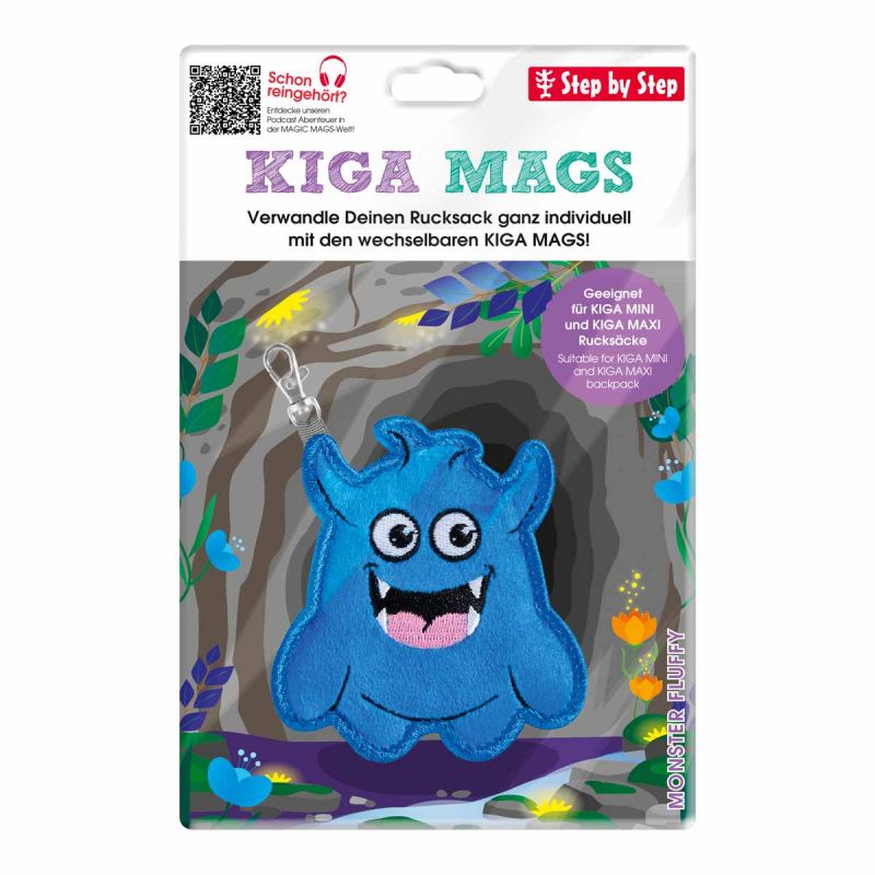 Blauer Monster-Schlüsselanhänger mit drei Augen, lächelnd, auf bunter KIGA MAGS-Verpackung von Step by Step.