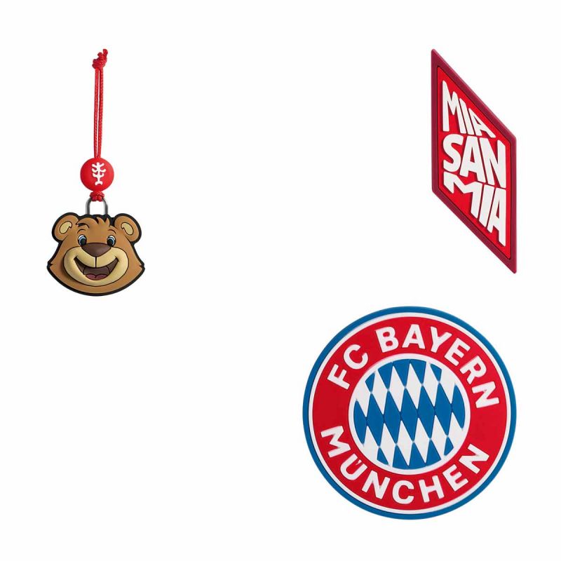Drei FC Bayern München Schlüsselanhänger: ein Bär, ein rotes "Mia San Mia"-Schild und das Club-Logo.