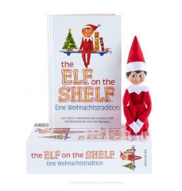 Elf on the Shelf-Puppe sitzt neben zwei Exemplaren des Buches The Elf on the Shelf: Eine Weihnachtstradition.