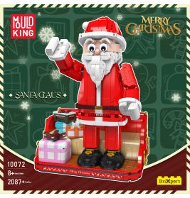 Spielzeug-Weihnachtsmann aus Bausteinen winkt, steht bei Geschenken, darüber Frohe Weihnachten.