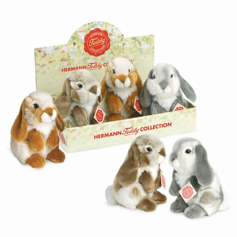 Plüschhasen in verschiedenen Farben in einer Box mit der Aufschrift Hermann Teddy Collection ausgestellt.