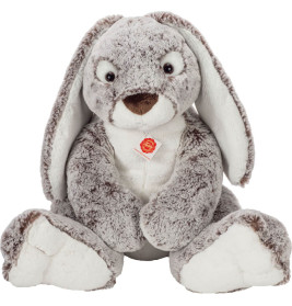 Grau-weißes Plüschkaninchen mit langen Ohren, sitzt aufrecht und trägt ein rot-goldenes Schild auf der Brust.