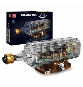 Klares Kunststoff-Schiffsmodell in Flasche mit Ständer, neben Karton mit Aufschrift Creative Idea präsentiert.