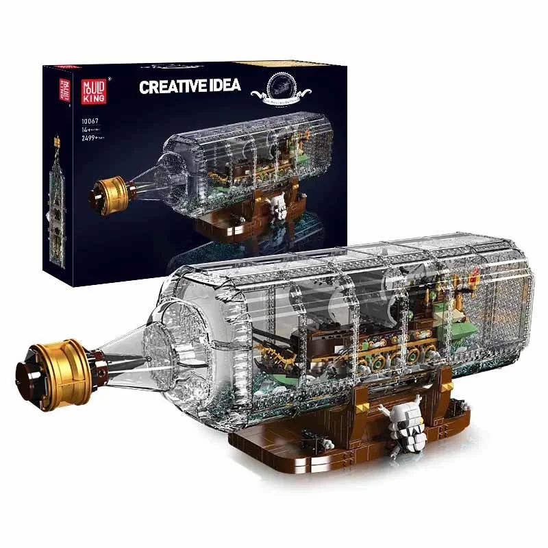 Klares Kunststoff-Schiffsmodell in Flasche mit Ständer, neben Karton mit Aufschrift Creative Idea präsentiert.