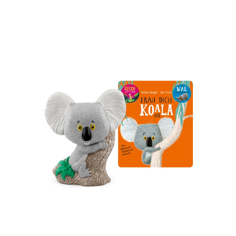Spielzeug-Koala auf einem Baum, im Hintergrund ein oranges Buch: Trau Dich, Koala-Bär. Spielzeug-Koala auf einem Baum, im Hintergrund ein oranges Buch: Trau Dich, Koala-Bär.