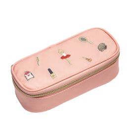 Rosa Reißverschlusstasche mit kleinen Deko-Pins: Ballerina, Spiegel, Lippenstift und Muschel auf der Oberseite.