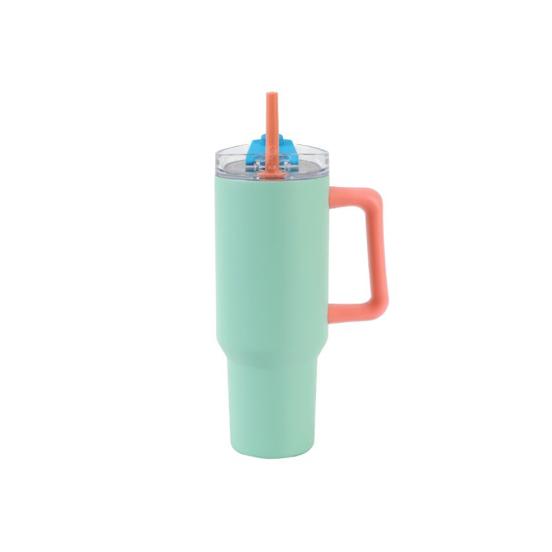 Minzgrüner Becher mit Korallengriff, Klarsichtdeckel und orangem Strohhalm vor weißem Hintergrund. Minzgrüner Becher mit Korallengriff, Klarsichtdeckel und orangem Strohhalm vor weißem Hintergrund.