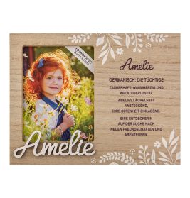 Holzrahmen mit Foto eines lächelnden Mädchens, Name Amelie und deutscher Beschreibung daneben.
