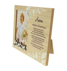 Holzrahmen mit weißen Blumen, Kinderfoto, Name Anton und deutscher Beschreibung.