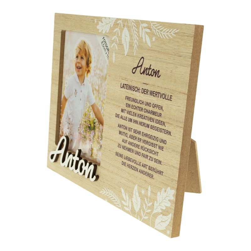 Holzrahmen mit weißen Blumen, Kinderfoto, Name Anton und deutscher Beschreibung.