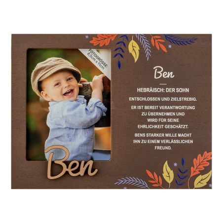 Lächelnder Junge mit Mütze im braunen Rahmen, daneben "Ben" und deutscher Text, verziert mit bunten Blättern.