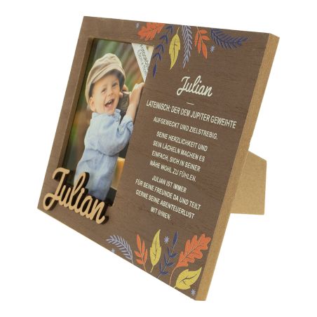 Holzrahmen mit Herbstblättern, Foto eines lächelnden Jungen, Name Julian und eine deutsche Nachricht.