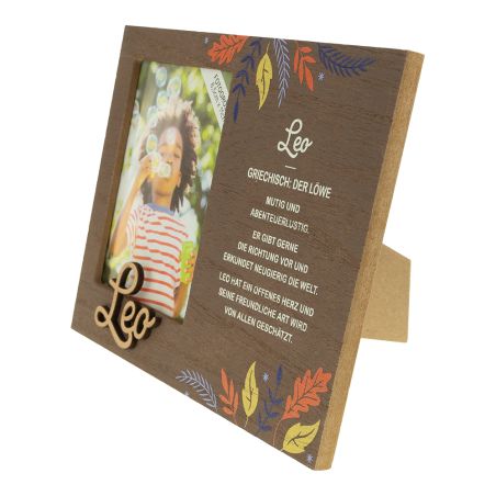 Holzrahmen mit "Leo"-Text, bunten Blättern und kurzer Beschreibung des Sternzeichens Löwe auf Deutsch.