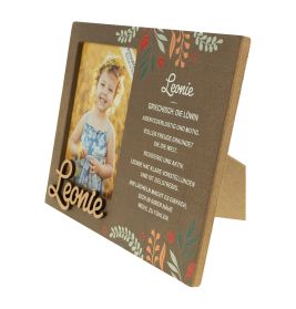 Holzrahmen mit Blumenmuster, Kinderfoto, Name Leonie und beschreibender deutscher Text.