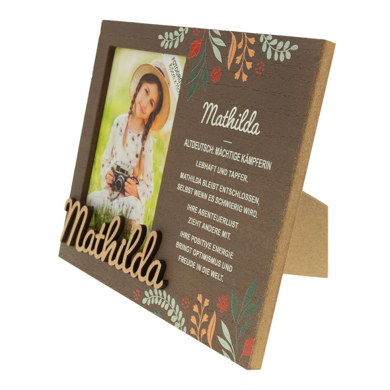 Holzrahmen mit "Mathilda" und Blumenmotiven zeigt das Porträt eines lächelnden Mädchens mit Hut.