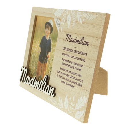 Holzrahmen mit Foto eines Kindes, dem Schriftzug "Maximilian" und einer deutschen Namensbeschreibung.
