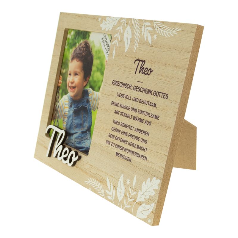 Holzrahmen mit Foto eines lächelnden Kindes und deutschem Text neben dem Namen "Theo".