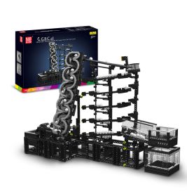 Schwarze und graue Murmelbahn mit weißen Kugeln, im Hintergrund die bunte Verpackung.