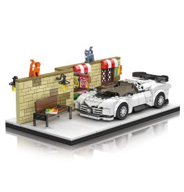 LEGO-Sportwagen in Weiß steht an einer Backsteinmauer mit zwei Katzen, einer Bank und bunten Markisen.