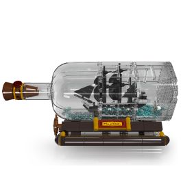 LEGO-Schiff in klarer Kunststoffflasche auf braunem Ständer, verziert mit blauen Dekoelementen.