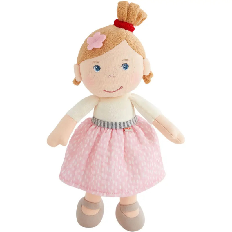 Stoffpuppe mit blonden Haaren, rosa Rock, grauen Schuhen und rosa Blume im Haar. Stoffpuppe mit blonden Haaren, rosa Rock, grauen Schuhen und rosa Blume im Haar.