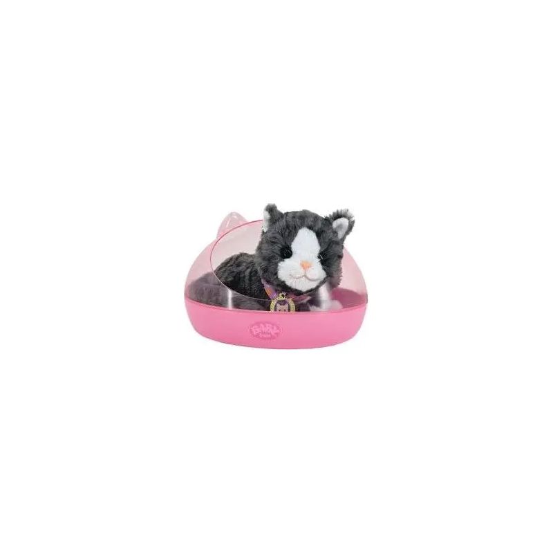 Schwarz-weißes Stoffkatzen-Spielzeug sitzt nach vorne gerichtet in einem pinken Plastikbett. Schwarz-weißes Stoffkatzen-Spielzeug sitzt nach vorne gerichtet in einem pinken Plastikbett.