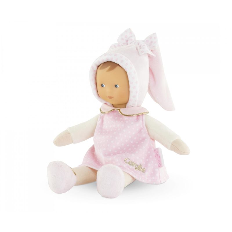 Weiche Babypuppe mit rosa gepunktetem Kleid und passender Mütze mit Schleife sitzt aufrecht.