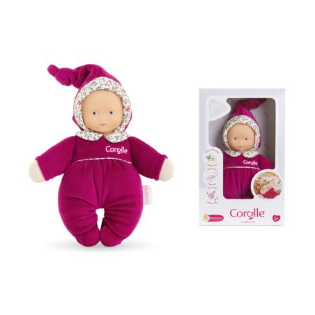 Weiche Babypuppe in lila Outfit und Blumenhut neben ihrer Corolle-Verpackung. Weiche Babypuppe in lila Outfit und Blumenhut neben ihrer Corolle-Verpackung.