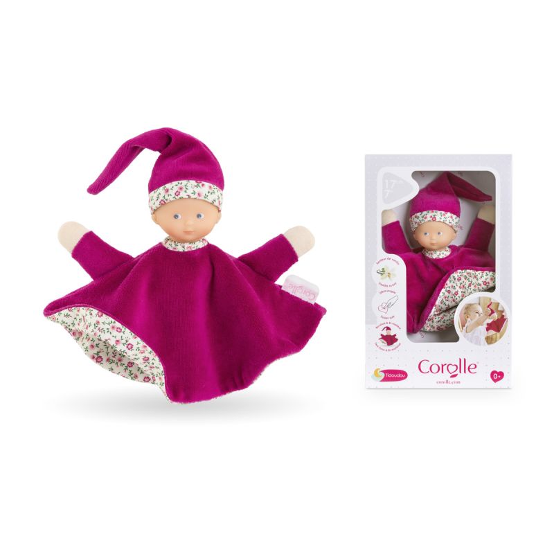 Plüsch-Babypuppe mit magentafarbener Kleidung und Mütze neben passender Verpackung. Plüsch-Babypuppe mit magentafarbener Kleidung und Mütze neben passender Verpackung.