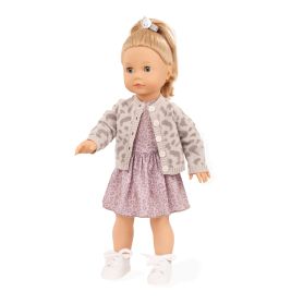 Blonde Puppe mit gemustertem Kleid, heller Strickjacke, weißen Schuhen und Zopf mit Schleife.