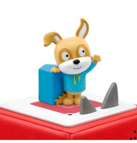 Eine Cartoon-Hundfigur im blauen Hoodie steht auf einer rot-weißen Lautsprecherbox.