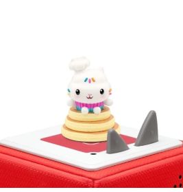 Eine niedliche Cupcake-Figur sitzt auf einer roten Audiobox mit grauen Knöpfen.