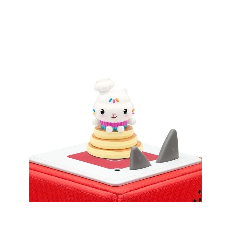 Eine niedliche Cupcake-Figur sitzt auf einer roten Audiobox mit grauen Knöpfen.