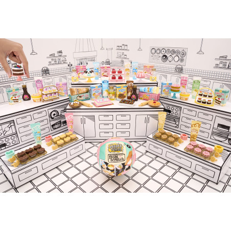 Eine Hand zeigt auf bunte Spiel-Backsets, die in einer schwarz-weiß illustrierten Küche arrangiert sind.