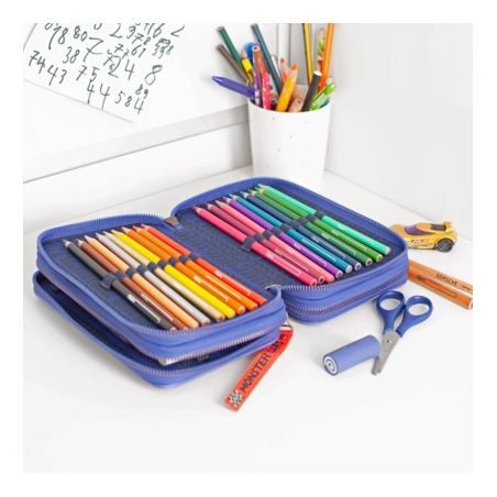 Offenes blaues Etui mit Buntstiften, Schere und Stiften auf weißem Schreibtisch mit Stiftebecher.